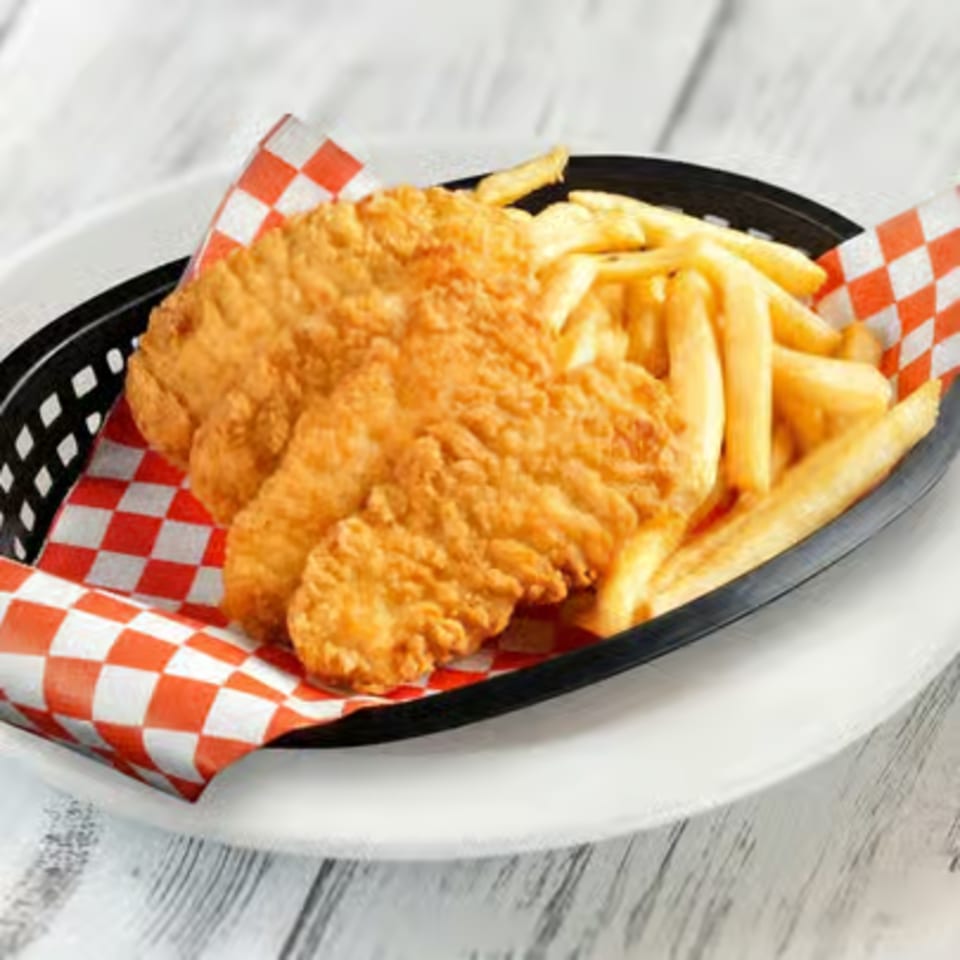 Crispy fried chicken tenders and golden french fries in a black basket with red and white checkered paper.