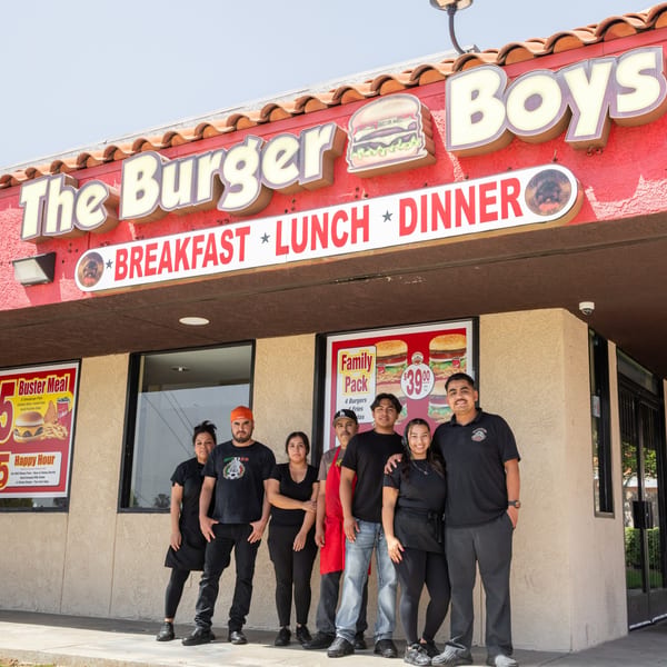 The Burger Boys restaurant exterior with seven staff members standing in front of the entrance.